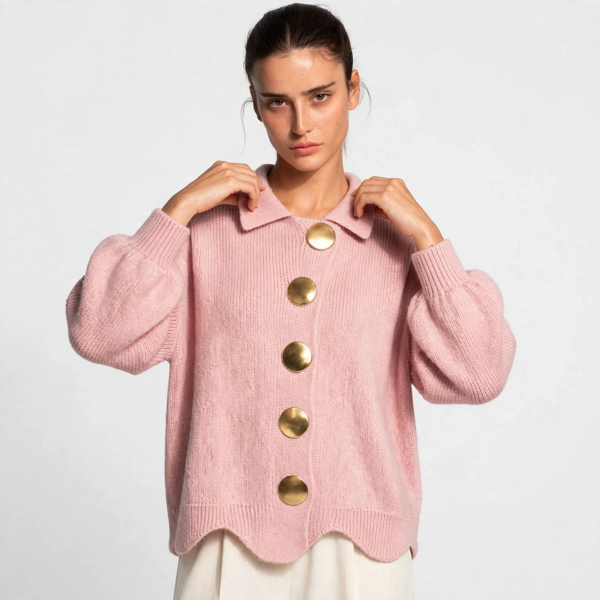 Woman wearing pink gold-button knit cardigan with lantern sleeves, front view