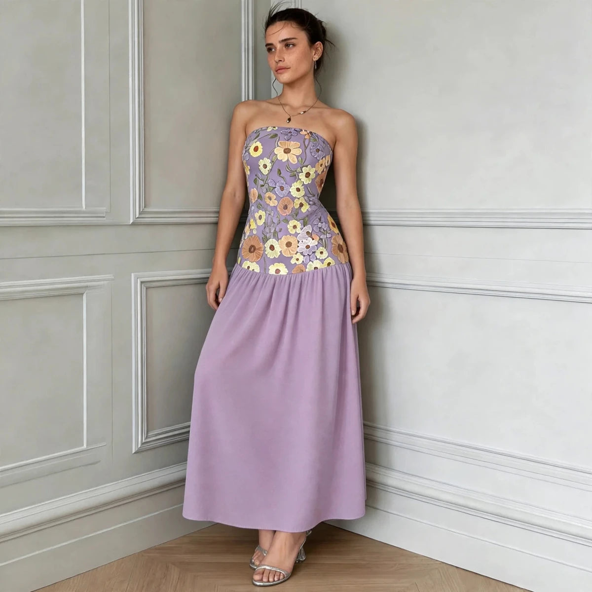 Model wearing purple floral embroidered tube maxi dress against paneled wall