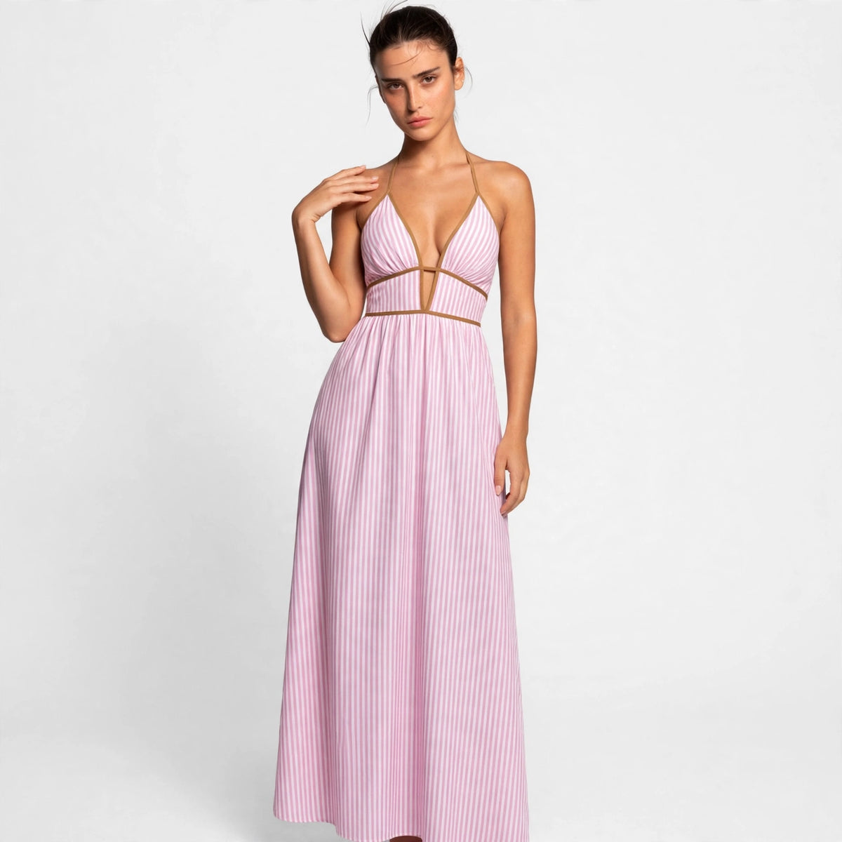 Model in pink striped smocked halter maxi dress with brown trim, front view