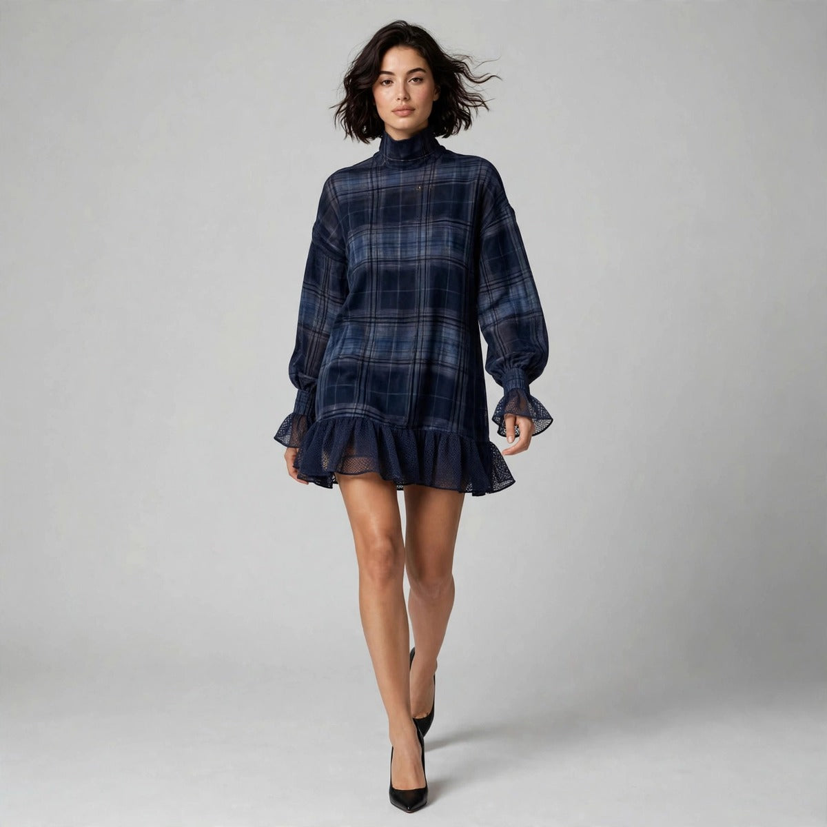 Model walking in navy plaid mini dress with lace ruffle hem