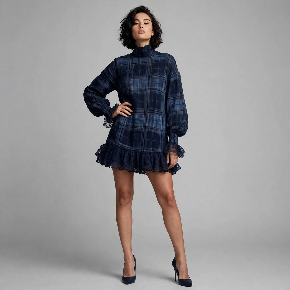 Woman wearing navy plaid mini dress with mock neck and lace ruffle hem