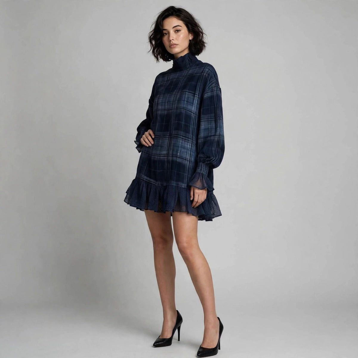 Three-quarter view of navy plaid mini dress with ruffled lace cuffs