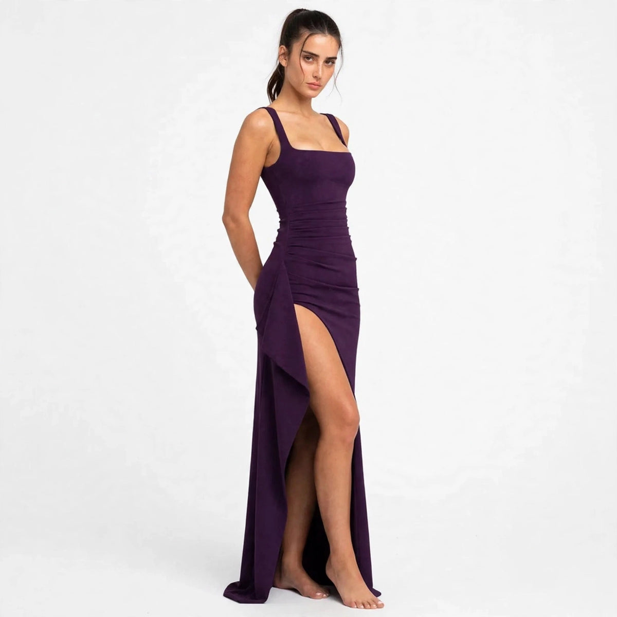 Woman wearing a purple ruched high-slit maxi dress with square neckline, front view