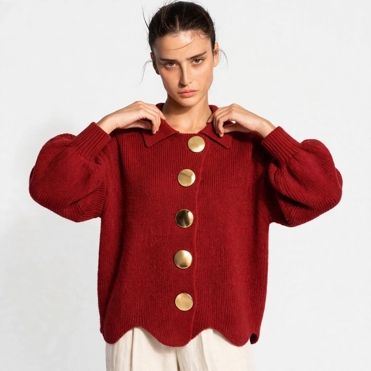 Woman wearing red gold-button knit cardigan with lantern sleeves, front view