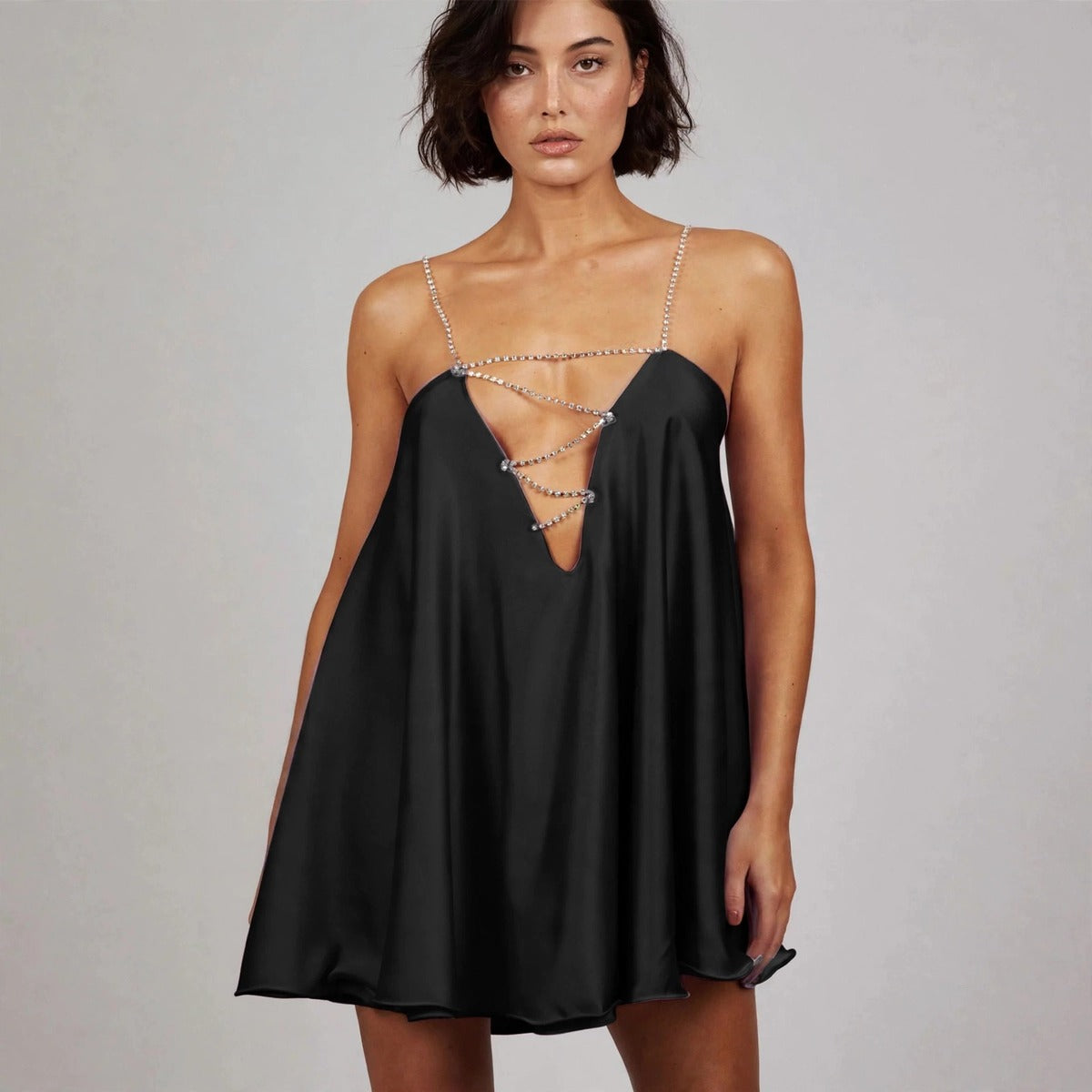 Woman wearing black rhinestone mini dress with chain-strap plunge neckline