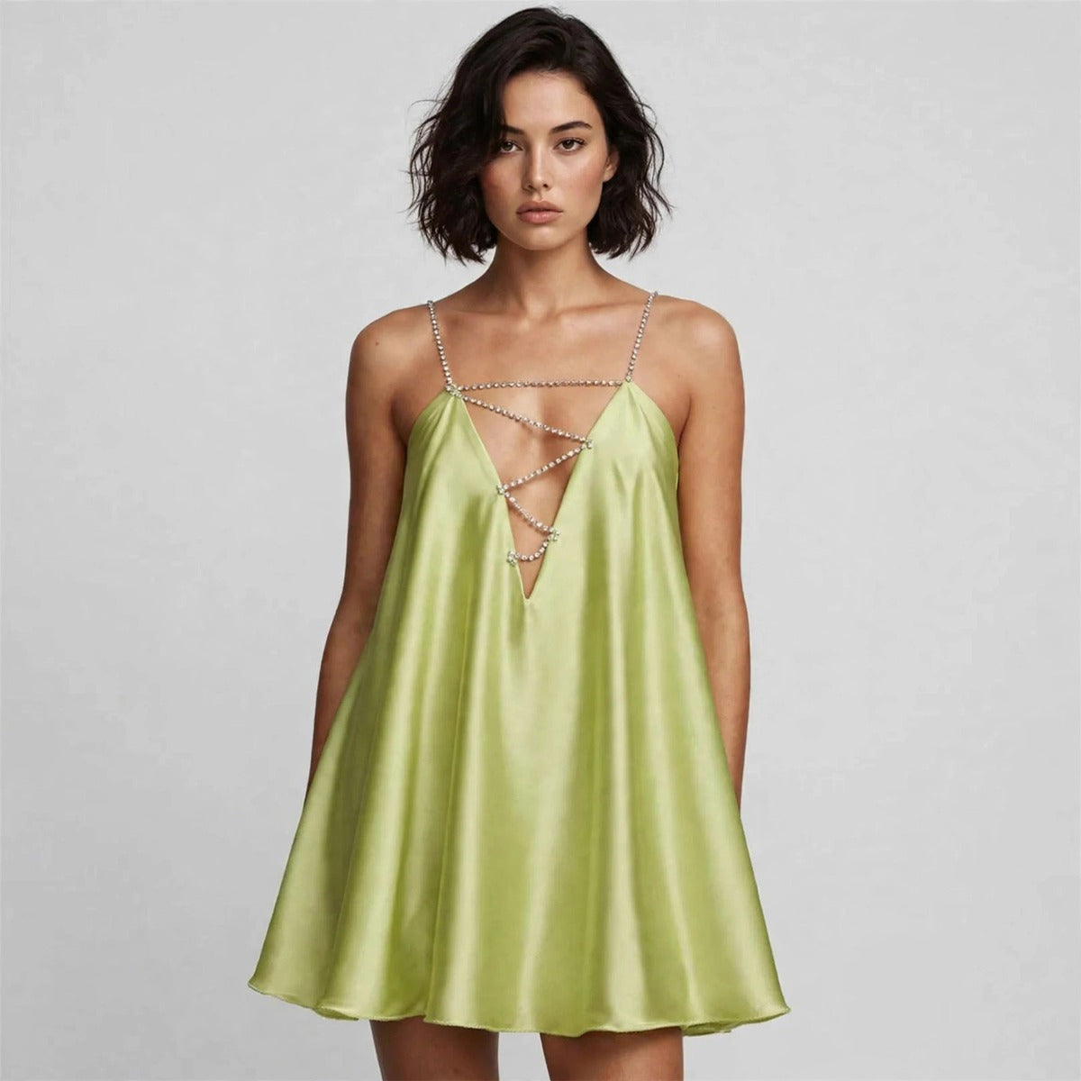 Woman wearing light green rhinestone mini dress with chain-strap plunge neckline