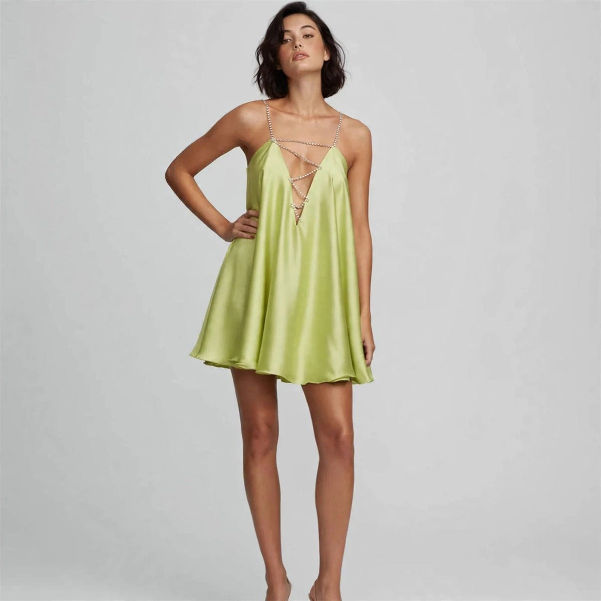 Model wearing light green rhinestone mini dress in a fashion editorial pose