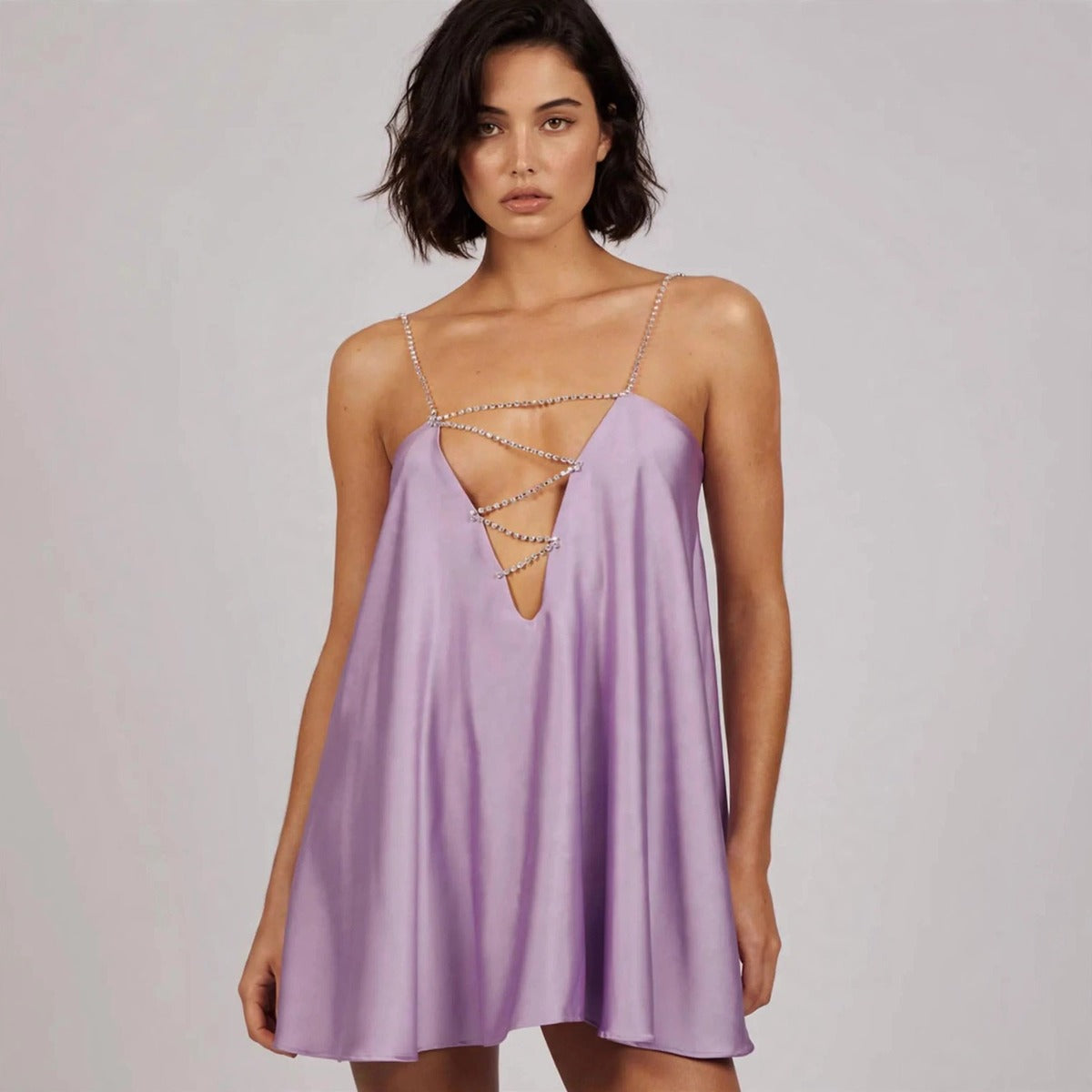 Woman wearing lavender satin rhinestone mini dress with embellished plunge front
