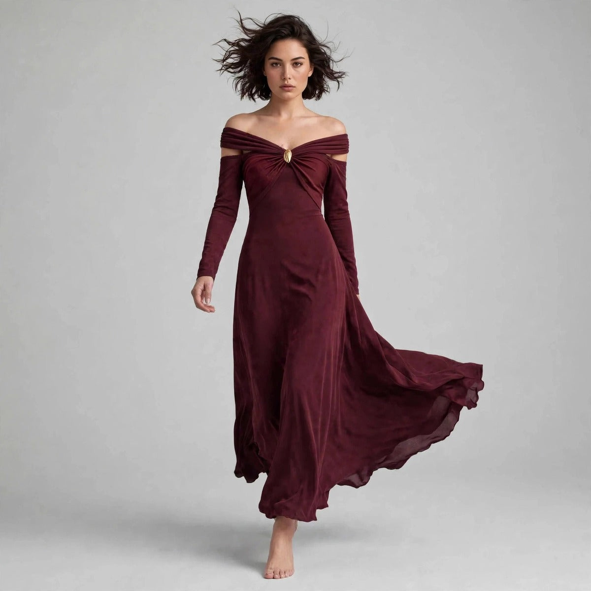 Model seated in burgundy off-shoulder ruched maxi dress in a fashion editorial
