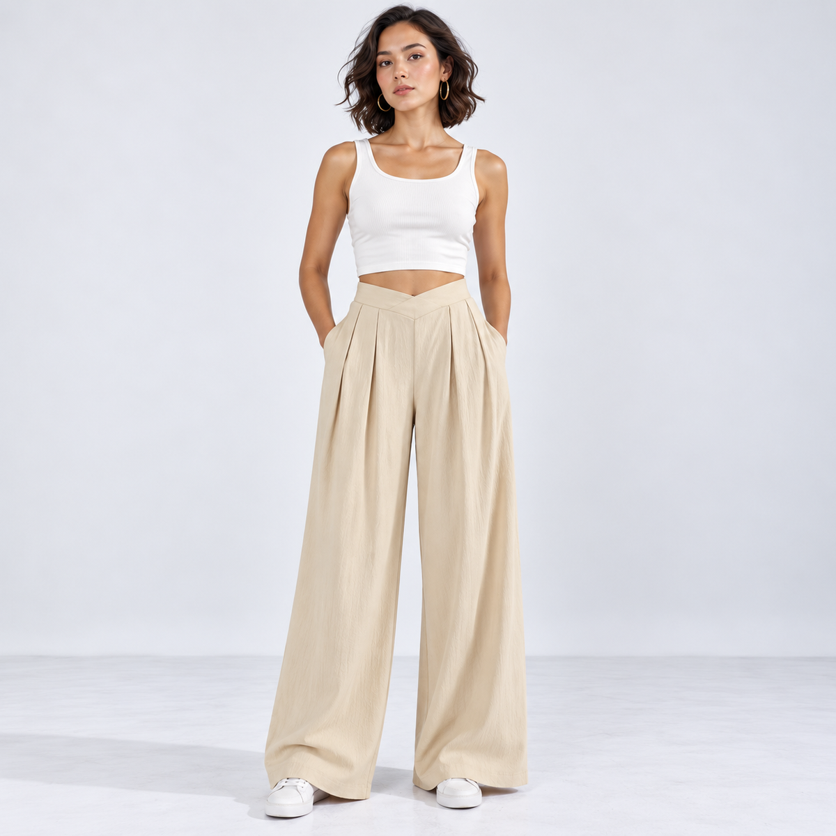 Woman wearing beige ruched wide-leg pants with crossover waistband, front view