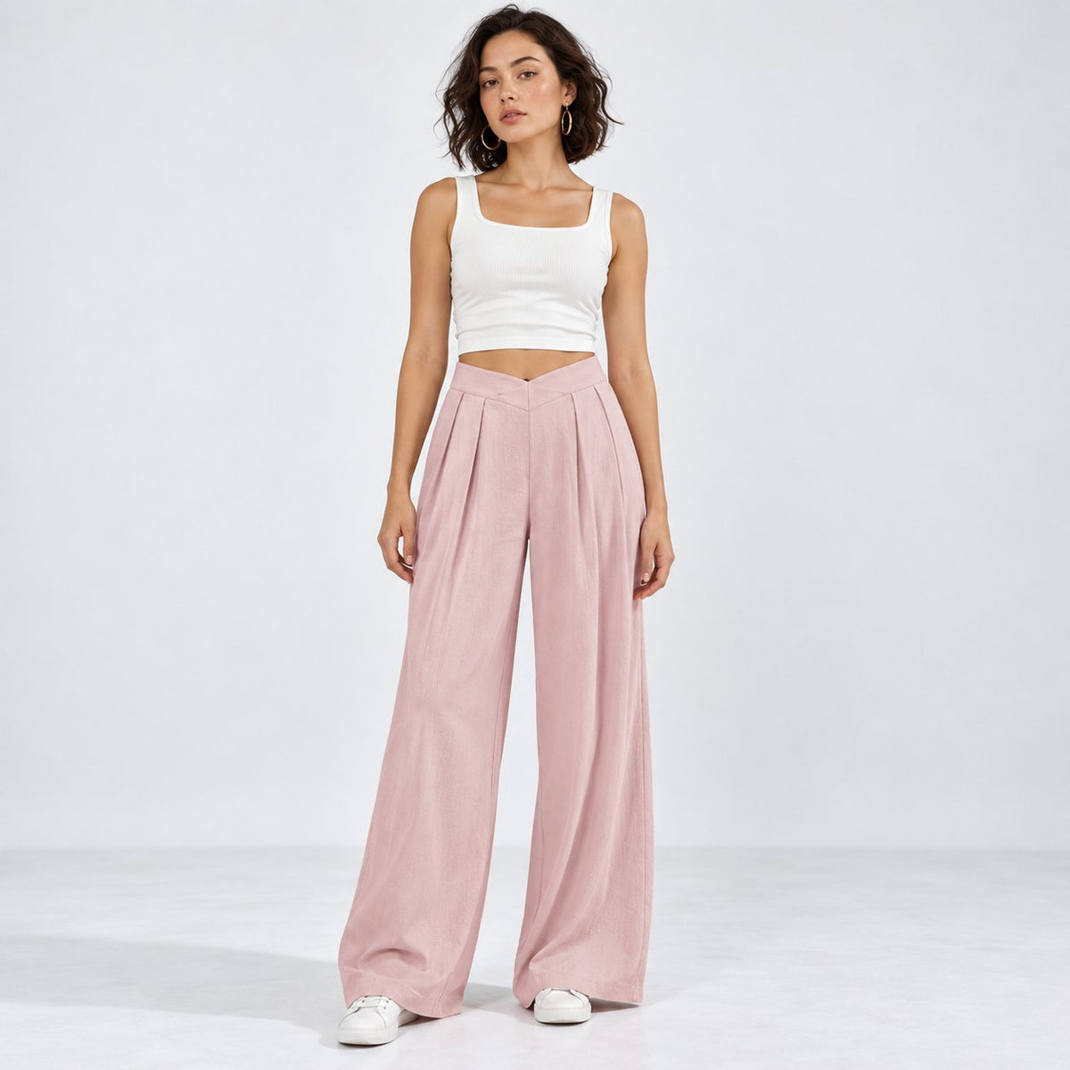 Woman wearing pink ruched wide-leg pants with crossover waistband, front view