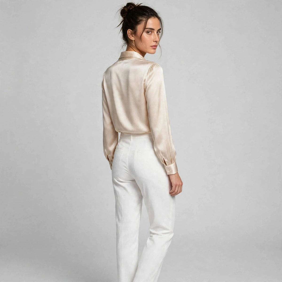Back view of beige satin tie-neck blouse with shawl collar