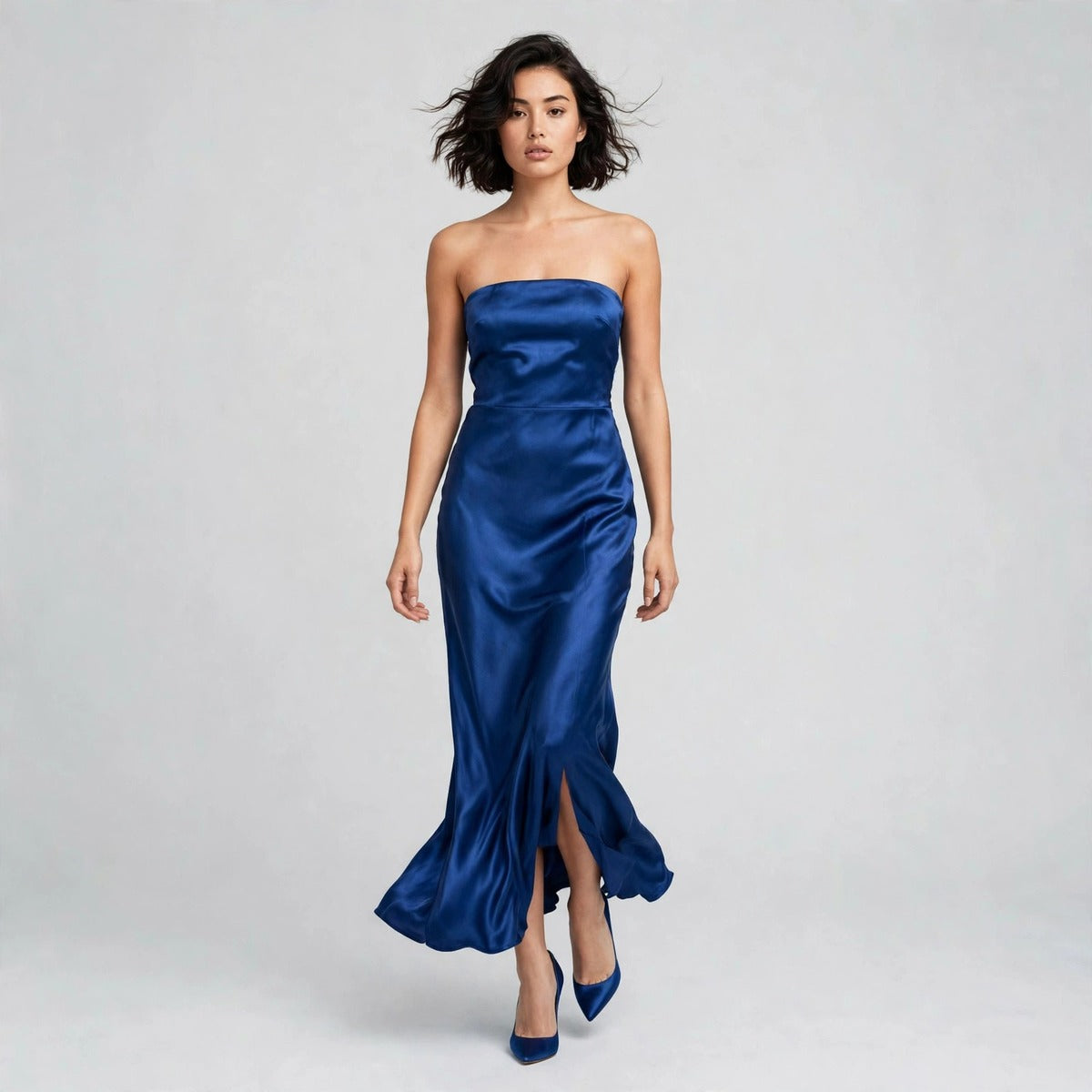 Model walking in royal blue satin strapless tube maxi dress in a campaign photo