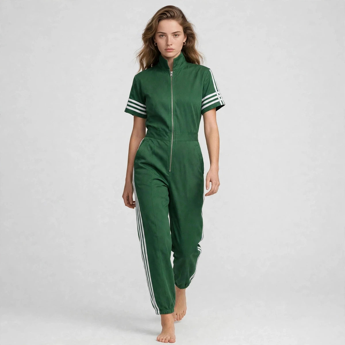 Women's green sporty striped jumpsuit, editorial studio shot