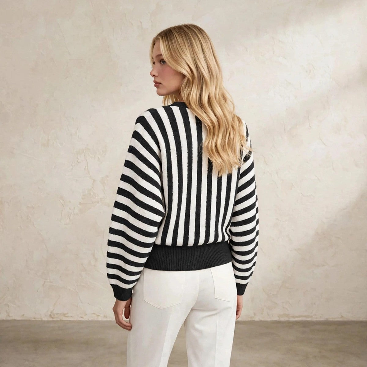 Women's black and white striped fuzzy knit crew neck sweater, back view over shoulder