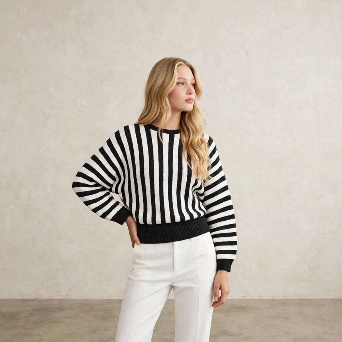 Women's black and white vertical striped crew neck sweater, hand on hip pose