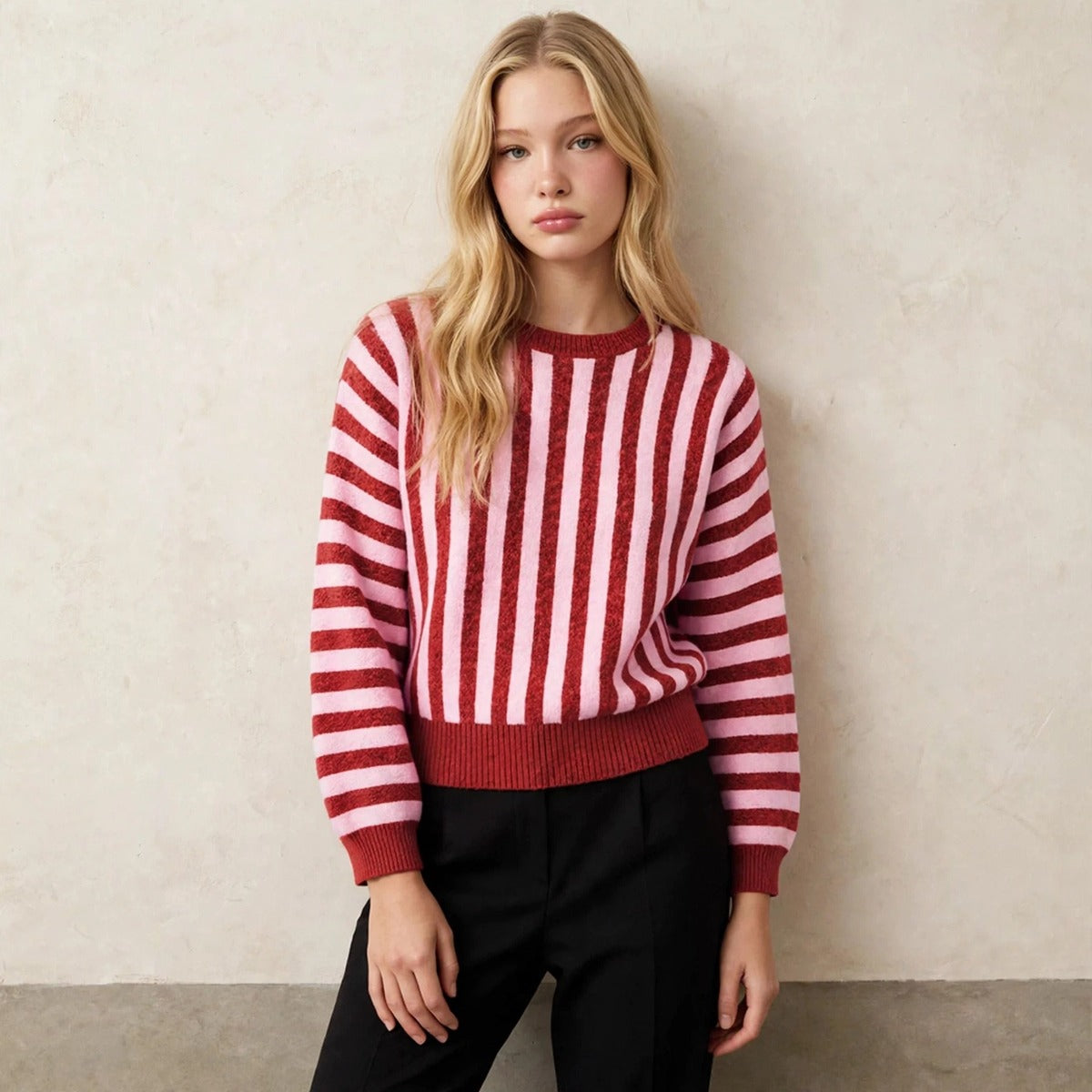 Women's deep red and pink striped sweater, relaxed leaning pose