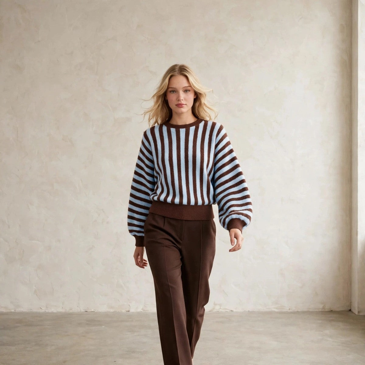 Women's light blue and brown striped crew neck sweater, walking pose
