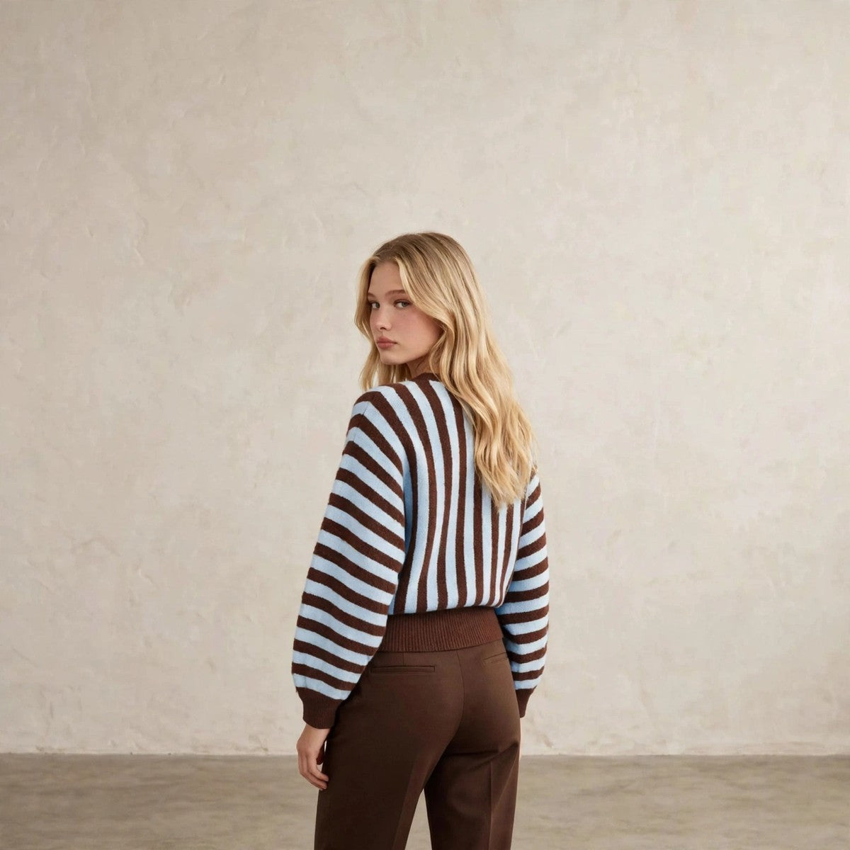 Women's light blue and brown striped fuzzy knit crew neck sweater, back view over shoulder