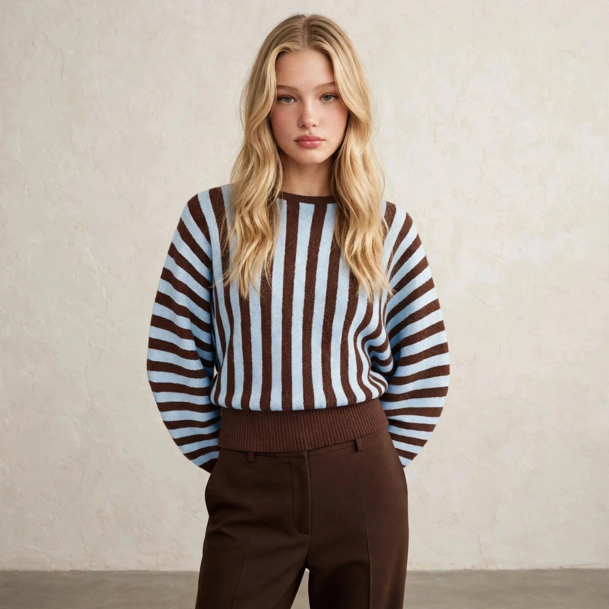 Women's light blue striped crew neck sweater with hands behind back