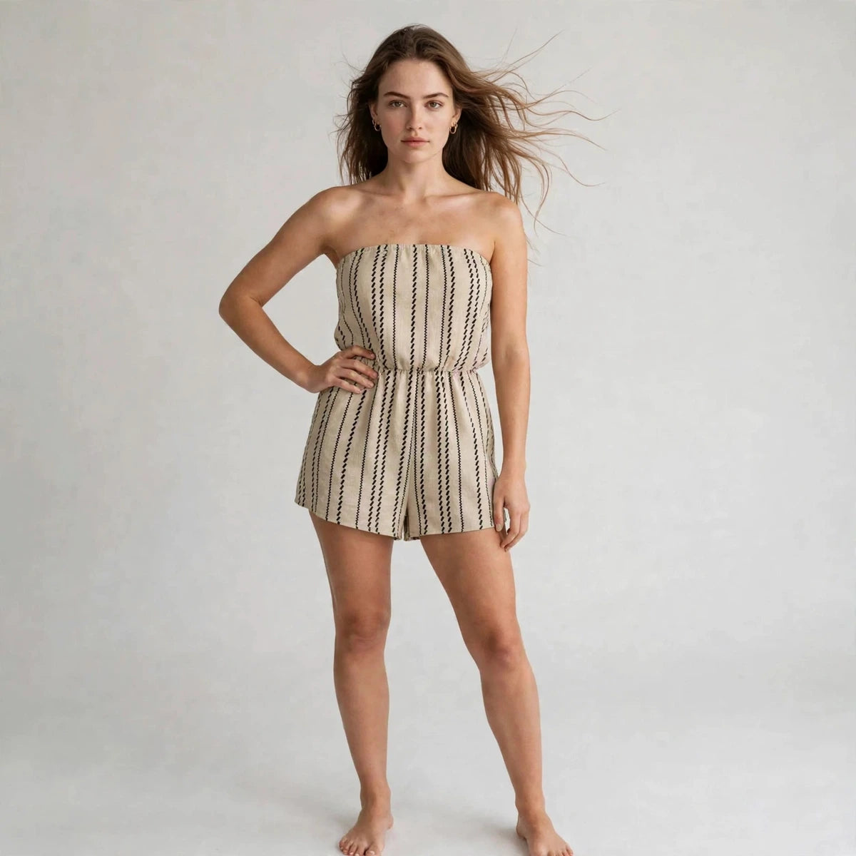 Woman wearing khaki striped strapless tube romper with elastic waist, front view