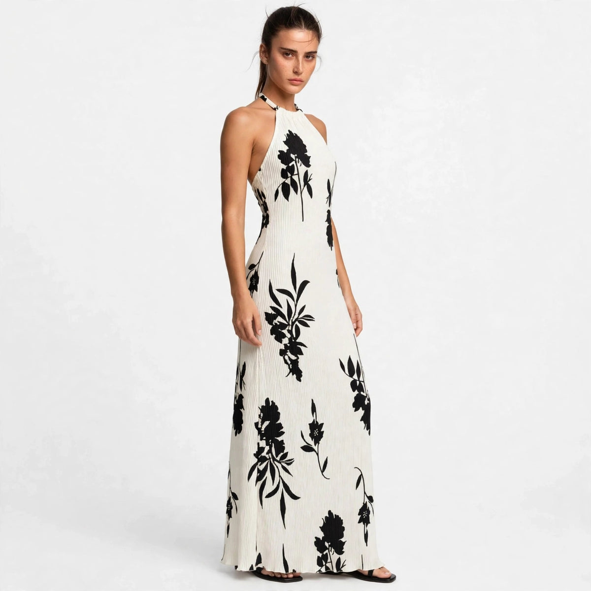 Woman wearing white floral halter maxi dress, front view
