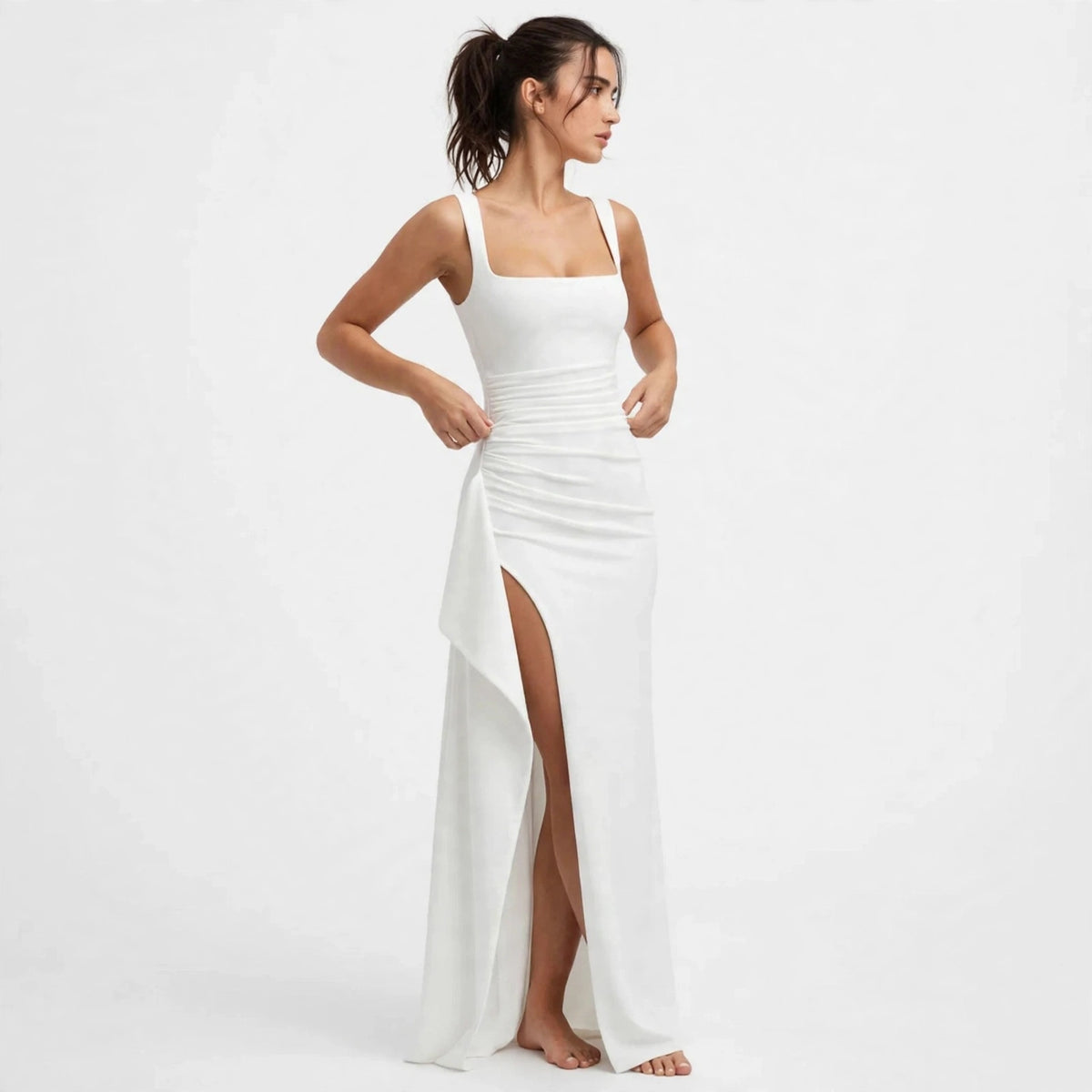 Three-quarter view of a white ruched high-slit maxi dress with high slit
