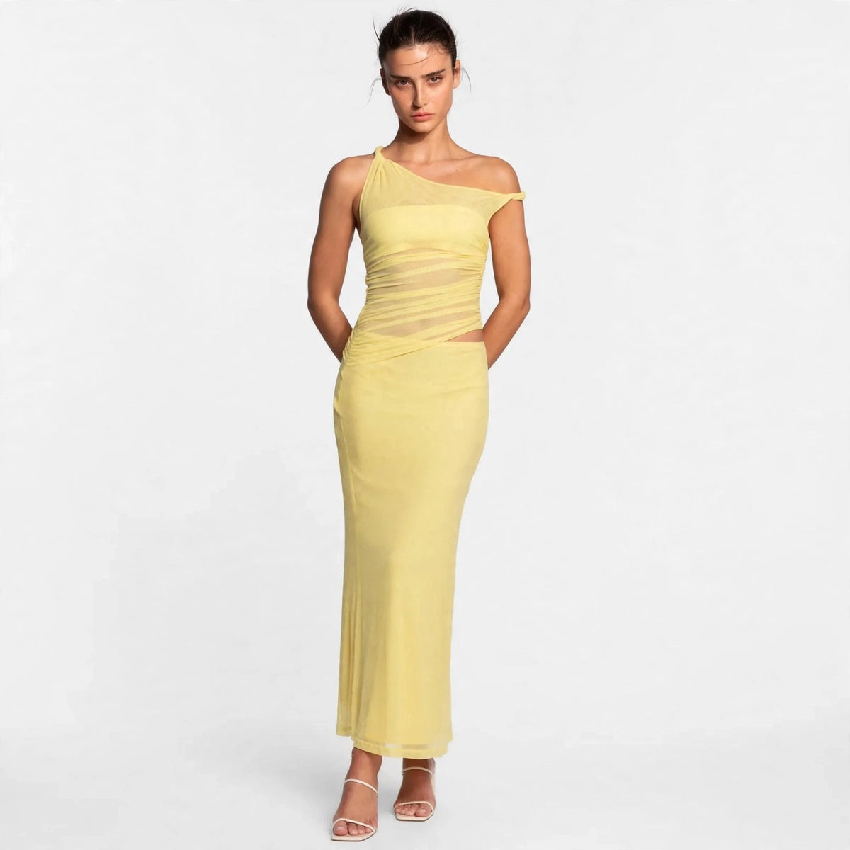 Woman wearing yellow asymmetrical cutout maxi dress, front view