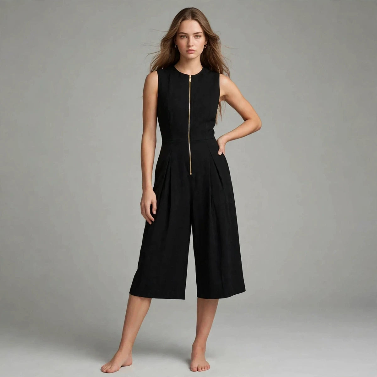 Woman wearing black sleeveless jumpsuit with front zipper, front view