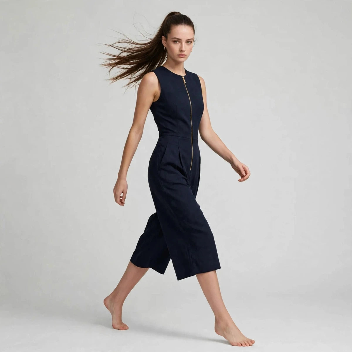 Women's dark blue jumpsuit with zipper pockets, editorial studio shot