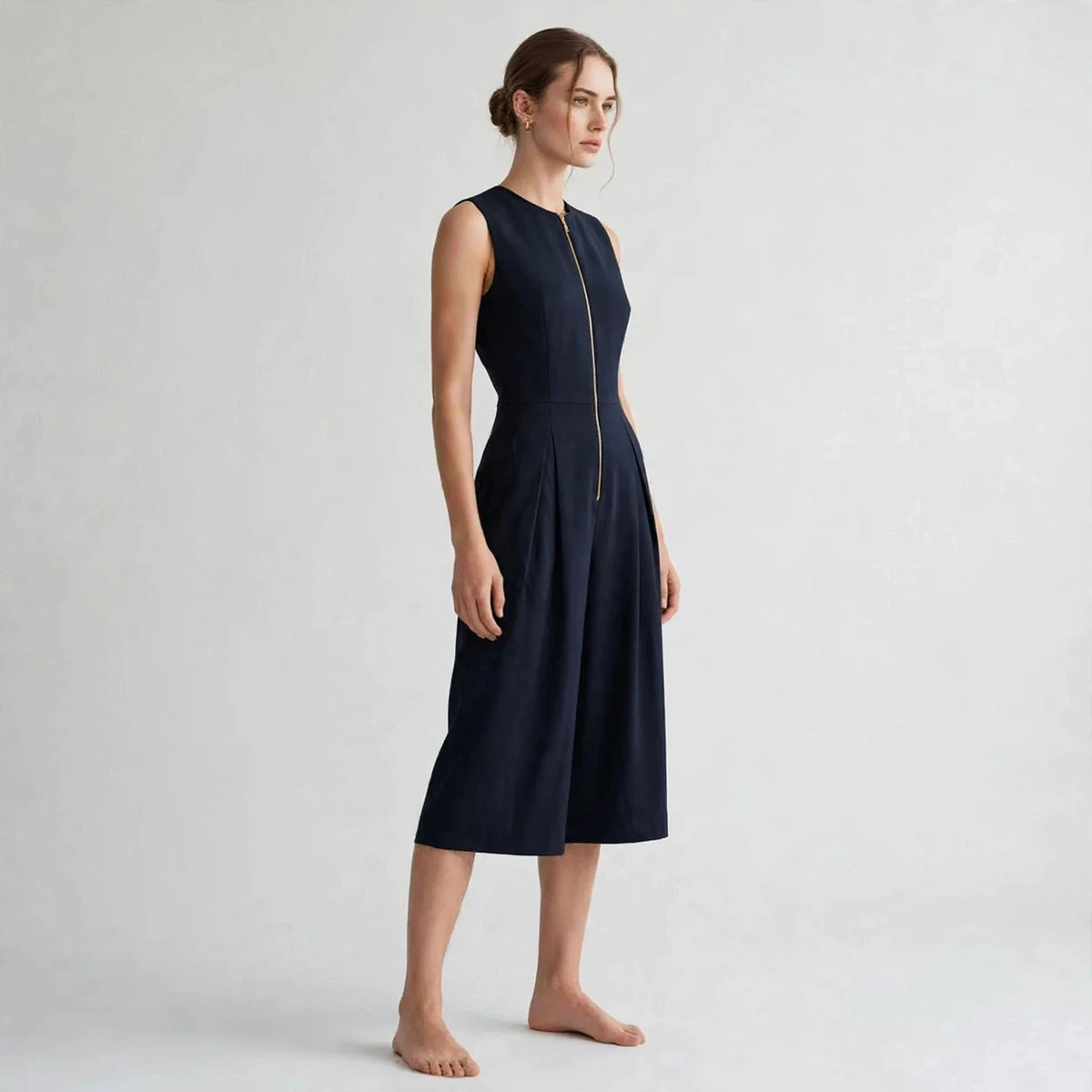 Women's dark blue jumpsuit with zipper pockets, side view