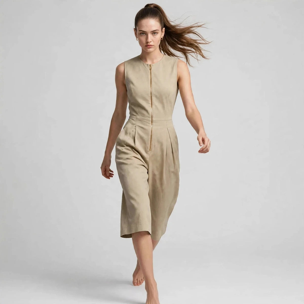 Model wearing khaki sleeveless zipper pocket jumpsuit walking in a fashion editorial